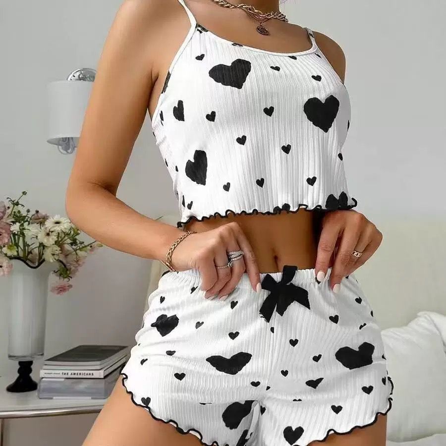 White pajama set with black heart prints and frilled hem, featuring a cropped tank and shorts for romantic loungewear.
