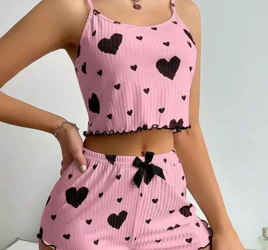 Pink pajama set with black heart prints and ruffled edges, a charming and cozy sleepwear duo.