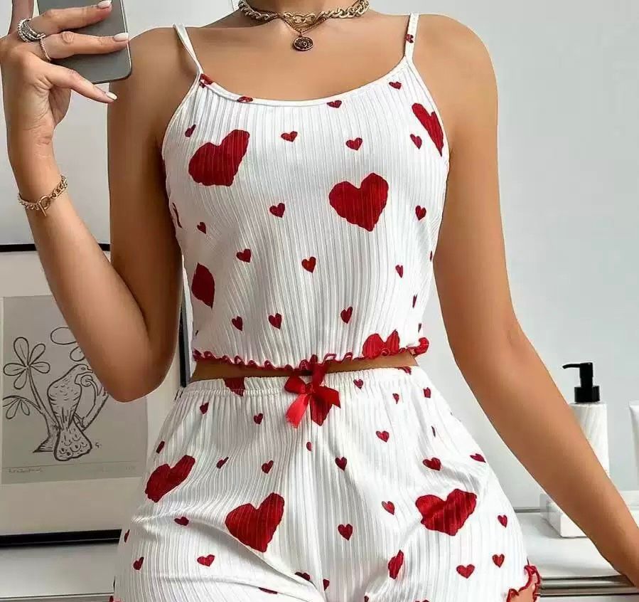 White pajama set with red heart prints and bow detail, featuring a cropped tank and shorts for a cute bedtime outfit.